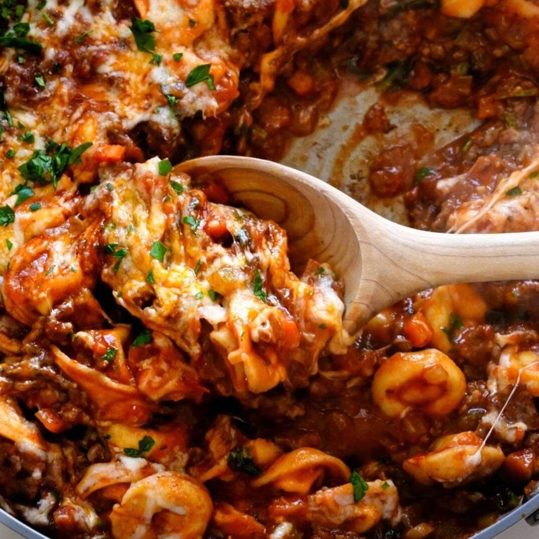 Baked tortellini served with spoon.