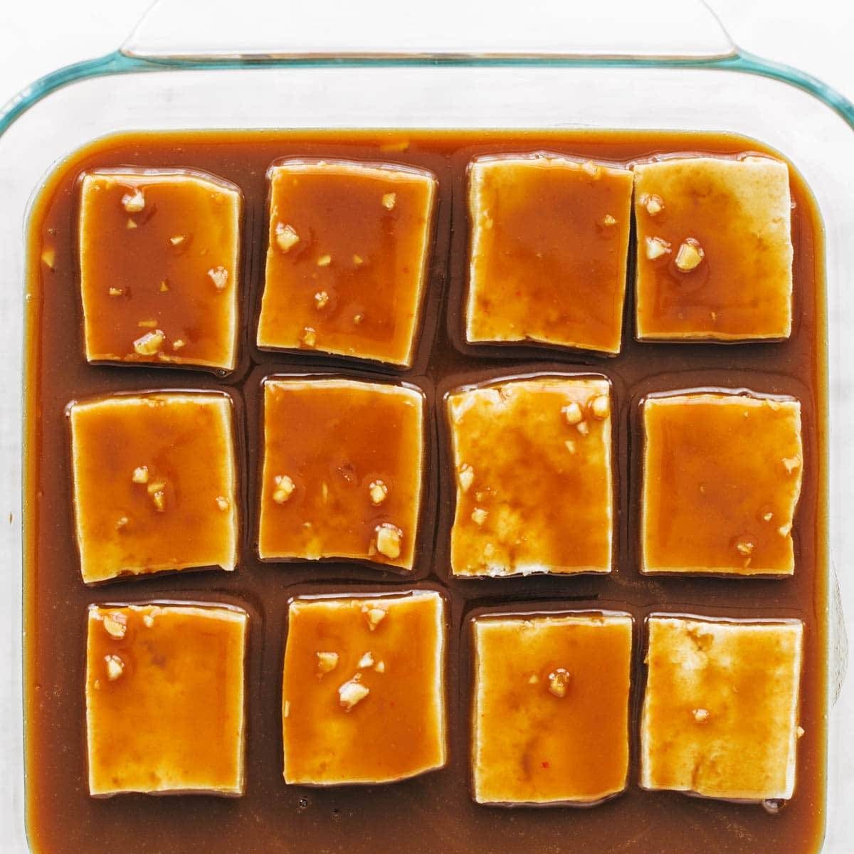 Tofu in baking pan with sauce.