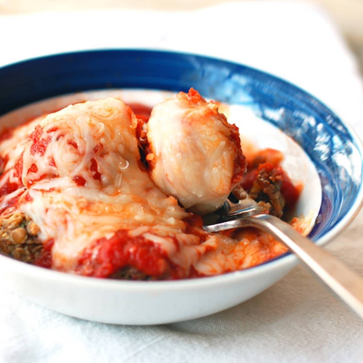 Meatless Meatballs with lentils and wild rice, and topped with marinara sauce and melted cheese. 